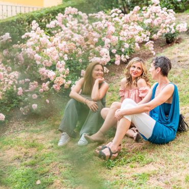 Distant view of three adult women sitting in the park talking. Beautiful mature women having a good time together in the park.